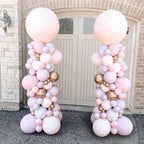 Balloon arches in pink and gold colors in front of a door.